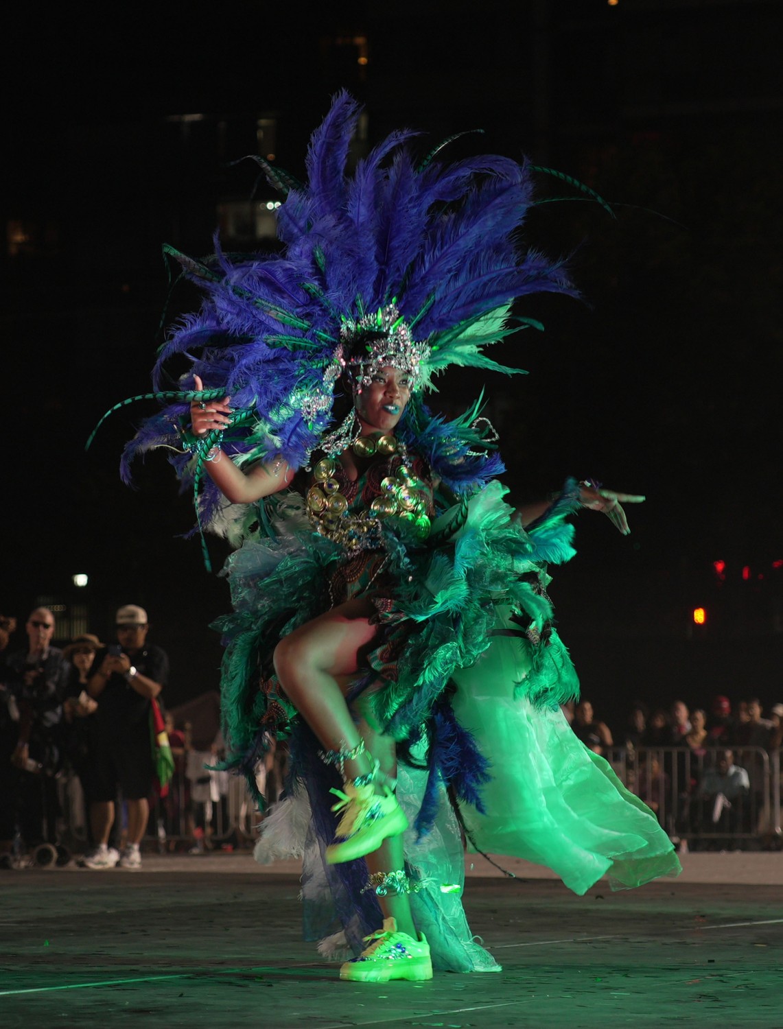 Micheala portraying Daughter of Xaymaca for Freedom Mas Band in a green and purple feathered costume.