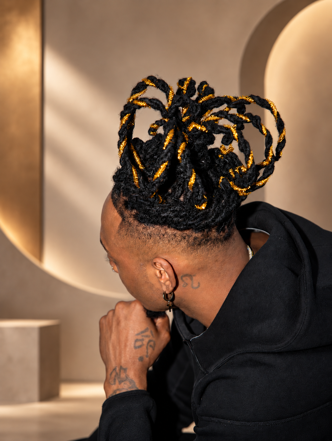 Featured model with sculptural braided loops decorated with gold accents at Beauty In You Hair and Makeup Show.